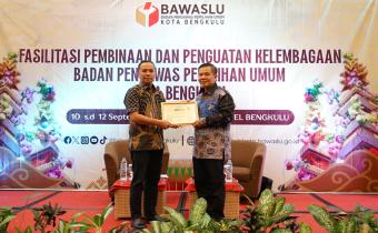 Ketua Bawaslu Kota Bengkulu Rahmat Hidayat (kiri) menyerahkan sertifikat Pemateri kepada narasumber Anggota TPD DKPP Provinsi Bengkulu Zacky Antoni..